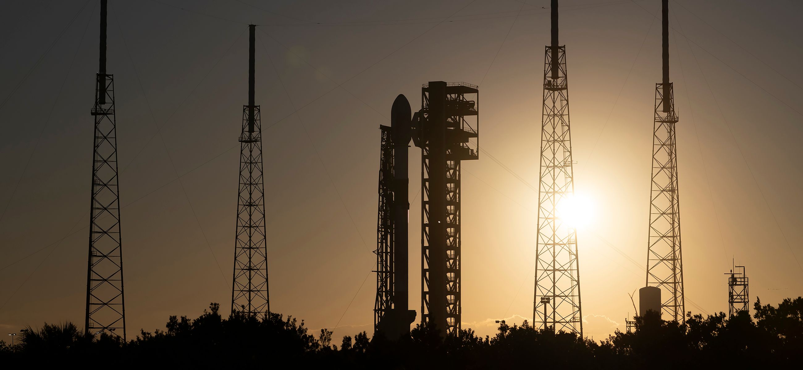 Falcon 9 silhouetted at the launch pad in the golden evening light